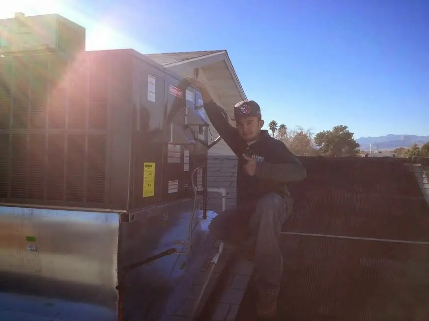 HVAC technician performing Air Duct Repair on a rooftop unit in St. Cloud